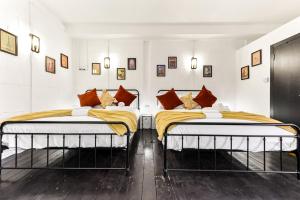 two beds in a room with white walls at Trendy and Eccentric Flat in Hackney in London