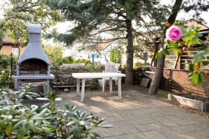 a white picnic table and a fireplace in a yard at Historical Malt Factory Apartment, 6 Bedrooms, sleeps 12 , Hot Tub in Helsingborg