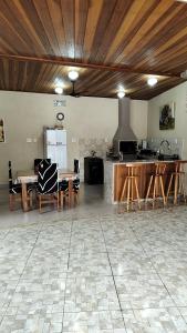 a large kitchen with a table and a stove at Cantinho da paz in Caraguatatuba