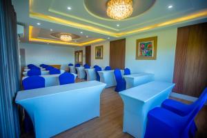 a conference room with blue chairs and tables at Horizon Hotel Romblon in Romblon