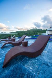 a pool with two lounge chairs on top of a building at Horizon Hotel Romblon in Romblon