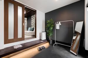 a room with a mirror and a pair of slippers at Yagara Terrace House D in Osaka