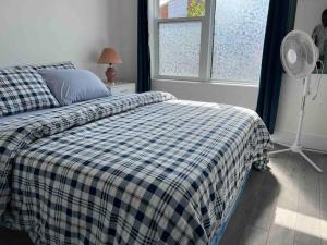 a bedroom with a bed with a blue and white checked blanket at ChrisTon Exotic Suite - A Homey Suite in Halifax