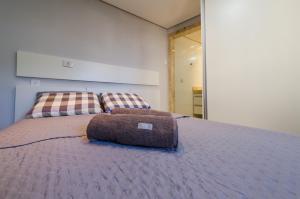 a bed with a pillow sitting on top of it at Studios Cor Eucarístico PREMIUM in Belo Horizonte