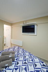 a bedroom with a large bed with a tv on the wall at Studios Cor Eucarístico PREMIUM in Belo Horizonte