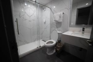 a bathroom with a shower and a toilet and a sink at Travelodge by Wyndham Whittier in Whittier