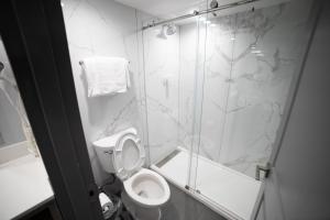 La salle de bains est pourvue de toilettes et d'une douche en verre. dans l'établissement Travelodge by Wyndham Whittier, à Whittier