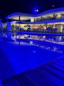 ein Gebäude in der Nacht mit Pool davor in der Unterkunft Makia Beach Experience in Ipojuca