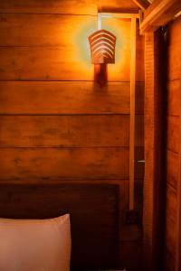 UragasmanhandiyaにあるCeylon Nature Paradiseのベッドルーム1室(ベッド1台付)、壁にランプが備わります。