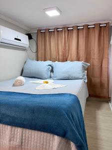 a bedroom with a bed with a blue blanket at Studios Cor Eucarístico PREMIUM in Belo Horizonte