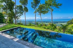 uma piscina de beiral infinito com vista para o oceano a partir de uma casa em Brisas Del Mar Hills of Portalón Ocean View em Savegre