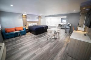 een kamer met een bed, een tafel en een bank bij Travelodge by Wyndham Whittier in Whittier