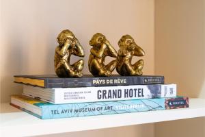 a stack of books with gold monkeys on top at Cosy Studio in Great Location! in London