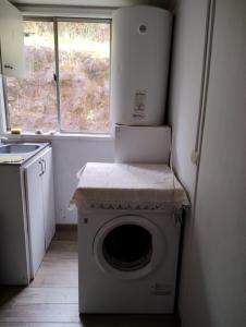 a washing machine in a kitchen with a window at Casa de campo al lado de la ciudad 130 mts2 in Valdivia