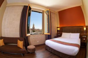 1 dormitorio con 1 cama, 1 silla y 1 ventana en ARIQUEPAY HOTEL, en Arequipa