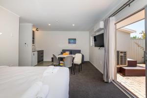 a bedroom with a bed and a table with chairs at Aurora City Suites Motel in Rotorua