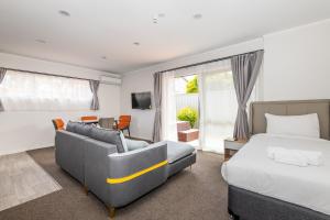 een hotelkamer met een bed en een bank bij Aurora City Suites Motel in Rotorua