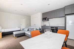 a kitchen and living room with a table and chairs at Aurora City Suites Motel in Rotorua