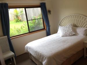 a bedroom with a white bed and a window at South Pacific in Scotts Head