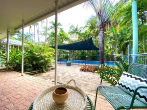 a patio with a table and a chair and a bowl on it at Project Tranquility, Magnetic Island in Nelly Bay