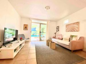 a living room with a couch and a tv at Project Tranquility, Magnetic Island in Nelly Bay