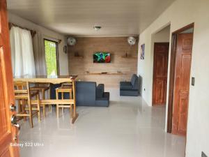 a dining room and living room with a table and chairs at Peluza's place in Puerto Jiménez