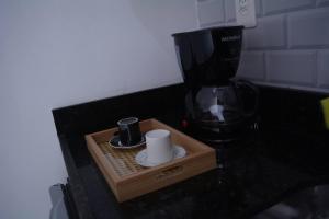 a coffee maker on a counter with a cup and a coffee mug at Flamengo Home in Rio de Janeiro