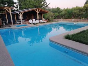 una gran piscina azul con cenador en Cabaña Bungalow SpA, en Quillón