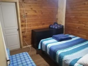 Habitación con 2 camas en una habitación de madera en Cabaña Bungalow SpA, en Quillón