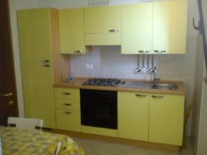 a kitchen with yellow cabinets and a sink at Casa Vacanza Holiday in Pieris