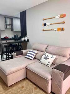 uma sala de estar com um sofá e uma cozinha em Lindo apt Garden Cannes Club em Florianópolis