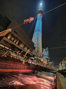 een hoge toren 's nachts met een rood en blauw bij SnowHouse in Tokyo