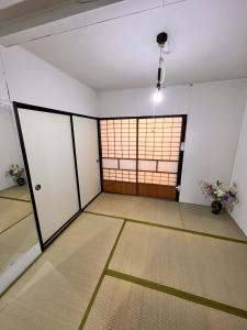 pusty pokój z drzwiami i oknem w obiekcie SnowHouse w Tokio