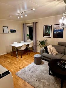 uma sala de estar com um sofá e uma mesa em Cozy 2-Bed Apartment on the top of Tromsø! em Tromsø