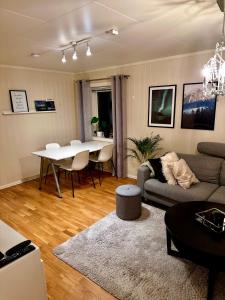 a living room with a couch and a table at Cozy 2-Bed Apartment on the top of Tromsø! in Tromsø