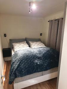 a bedroom with a bed with a blue comforter at Cozy 2-Bed Apartment on the top of Tromsø! in Tromsø