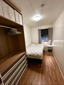 a small room with a bed and a window at Cozy 2-Bed Apartment on the top of Tromsø! in Tromsø