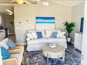 a living room with a white couch and a table at Tropical Gem/5 min beach walk in Panama City Beach +7 photos