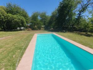 a blue swimming pool in a yard with trees at Trupan Green Spa in Trupán