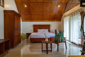 a bedroom with a bed and a table and chairs at Lush Acres in Thekkady
