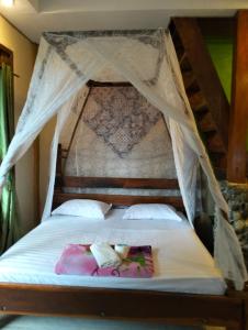 a bedroom with a bed with a canopy at Junia Guesthouse Bukit Lawang in Bukit Lawang