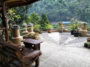 a patio with a wooden bench and potted plants at Junia Guesthouse Bukit Lawang in Bukit Lawang