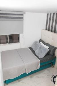 uma cama num quarto com uma janela em SU APARTAMENTO NEIVA CON AIRE Acondicionado em Neiva