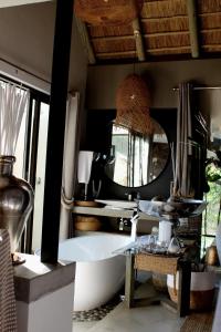 a bathroom with a tub and a large mirror at African Flair Boutique Safari Lodge in Hoedspruit