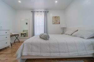um quarto branco com uma cama e uma cómoda em White Heaven House em Compton