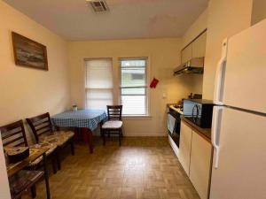 a kitchen with a table and a refrigerator and a table and chairs at Entire Beautiful 1BR for You! [R] in Whitestone