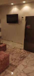 شقة مفروشة للايجار 4 في المنصورة: غرفة مع تلفزيون بشاشة مسطحة على الحائط