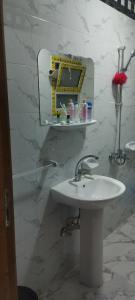شقة مفروشة للايجار 4 في المنصورة: حمام مع حوض أبيض ومرآة