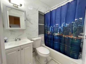a bathroom with a toilet and a shower curtain at Entire Beautiful 1BR for You! [R] in Whitestone