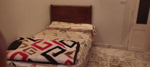 a small bed in a corner of a room at شقة مفروشة للايجار 4 in Mansoura